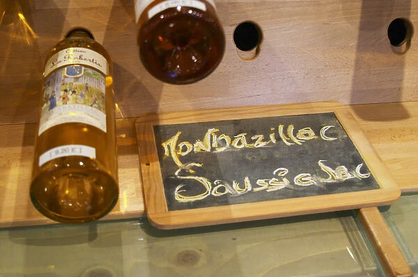 Golden yellow bottles of sweet white Bergerac and Monbazillac wine on display at
