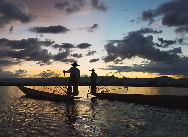 Intha fisherman rowing boat with leg at sunset on Inle Lake, Shan State, Myanmar