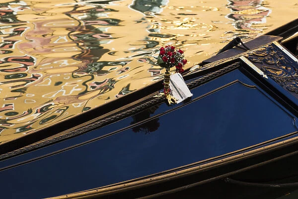 Italy, Venice. A gondola detail and colorful water reflections