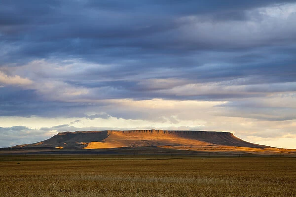 Morning sunlight breaks through the cloud cover and illuminates Square Butte near Great Falls