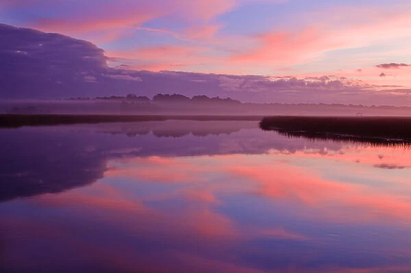 North America, USA, Georgia, Savannah. Clouds reflecting onto a creek at sunrise