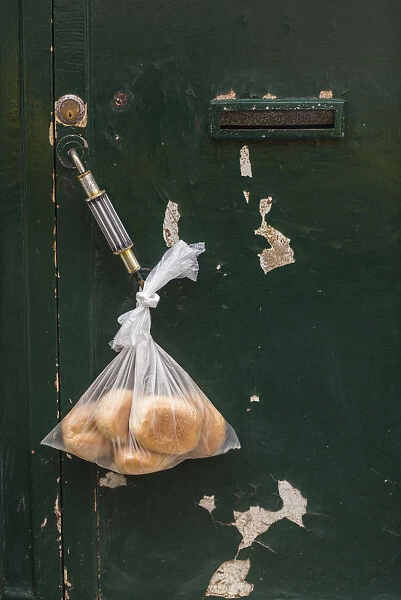 Portugal, Azores, Terceira Island, Angra do Heroismo. Bread roll delivery hanging on door