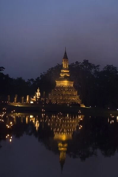 Stupa at Sukothai historical site lit up with candles for Loi Krathong