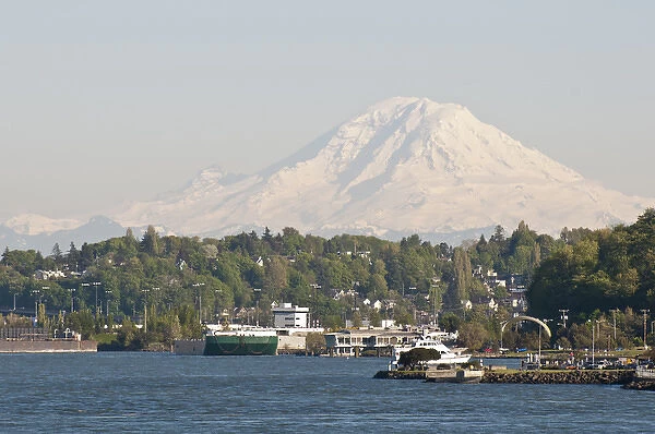 US, WA, West Seattle. Water taxi approaches Seacrest Dock. Mount Rainier looms to south