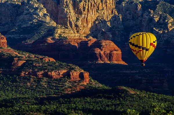 USA, Arizona. Hot-air balloon floats over Red Rocks State Park at sunset. Credit as