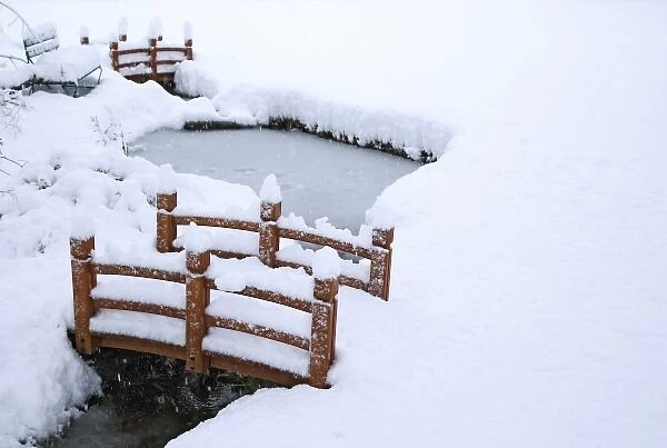 USA, California, Bishop. Snow-covered bridges and a pond