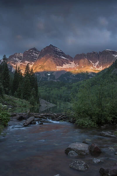 USA, Colorado, Maroon Bells State Park. Summer sunrise storm clouds on Maroon Bells mountains