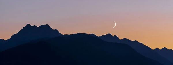 USA, Washington, Seabeck. Crescent moon and Venus over the Olympic Mountains. Credit as