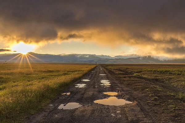 USA, Wyoming, Grand Tetons. Sunrise over mountains and road in landscape. Credit as
