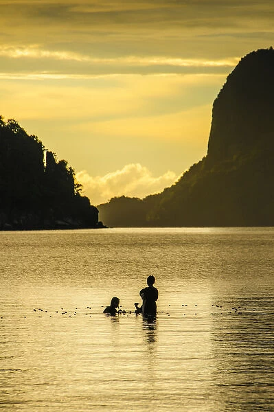 Young boys fishing at sunset in the bay of El Nido, Bacuit Archipelago, Palawan