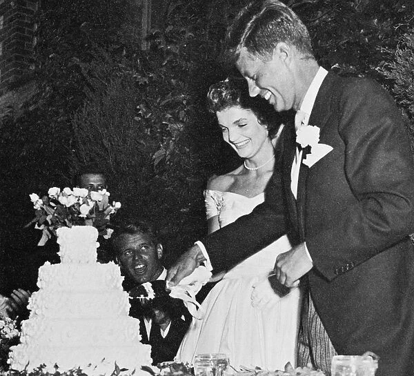 35th President of the United States. Photographed with his wife, Jacqueline Bouvier Kennedy, on the day of their wedding, 12 September 1953. Brother Robert F. Kennedy is seated at left