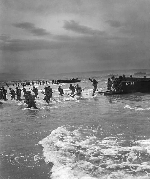 American troops leap off a U. S. Coast Guard landing craft to storm a North African beach during maneuvers to prepare for the invasion of Normandy, 1944