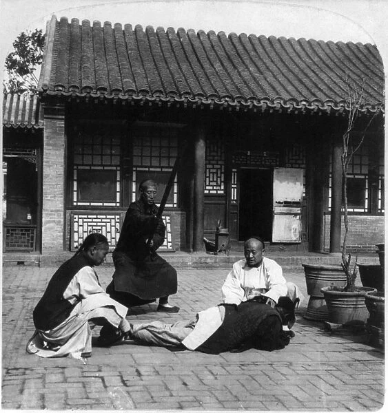 CHINA: PUNISHMENT, c1901. A Chinese husband receiving punishment for beating his wife
