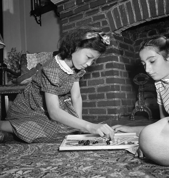 CHINESE CHECKERS, 1942. A Chinese-American girl playing Chinese checkers with her