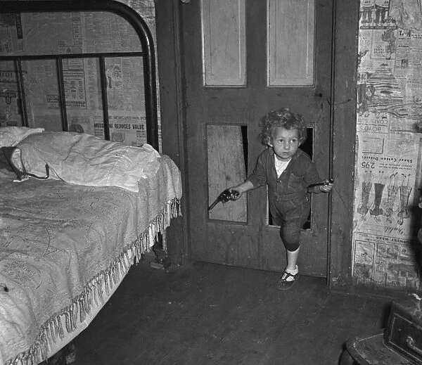COAL MINERs CHILD, 1938. Coal miners child using a hole in the door to enter