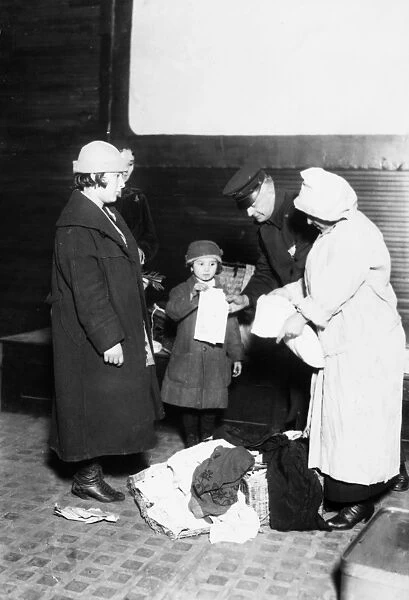 ELLIS ISLAND, 1921. A matron of the Health Department and a policeman examining