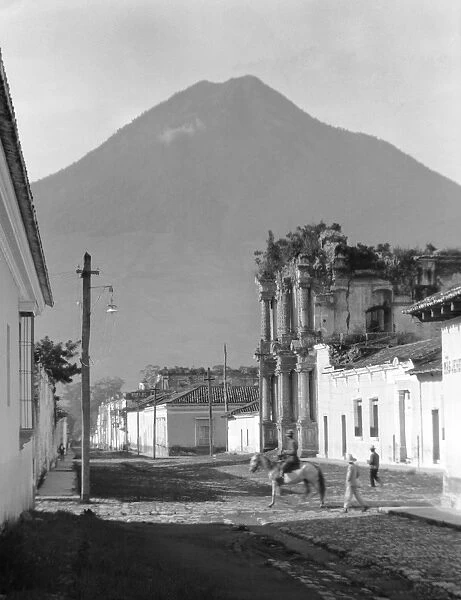 GUATEMALA, c1920. A street in Antigua, Guatemala, with Volcan de Agua in the background