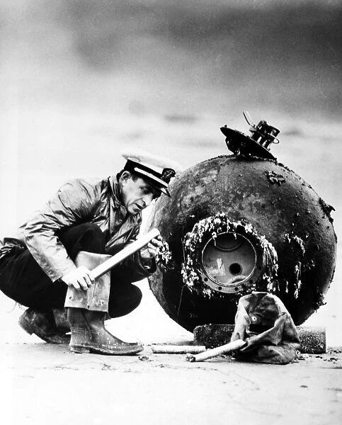Lieutenant D. F. Winslow of the U. S. Navy examines the detonator on a Japanese sea mine that had floated ashore near Newport, Oregon, 12 December 1947, more than two years after the end of World War II