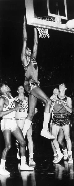 WILT CHAMBERLAIN (1936-1999). American basketball player. Chamberlain dunking the basketball while playing with the University of Kansas, c1956