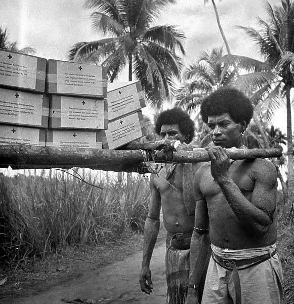 WORLD WAR II: NEW GUINEA. Natives of Papua New Guinea carrying blood plasma to