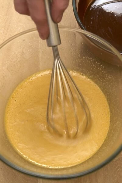 Beating a mixture of eggs, sugar and vanilla extract