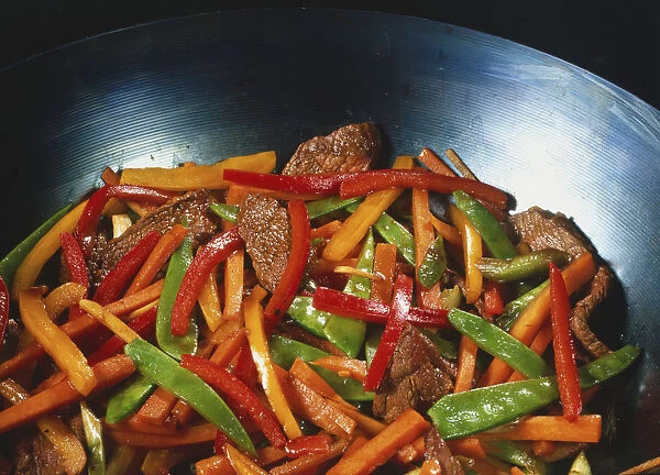 Beef and vegetable stir-fry in a wok, close up