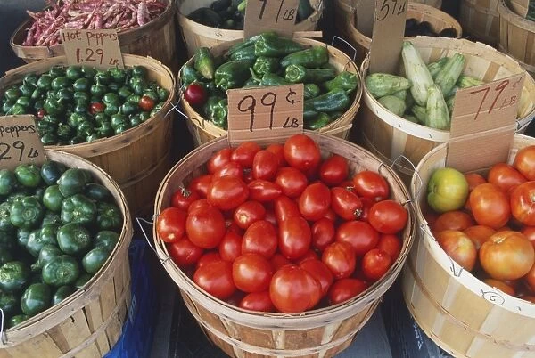 Canada, Ontario, Toronto, Little Italy, fresh vegetables, including tomatoes, green peppers and courgettes, on sale from wicker baskets, close up, high angle view