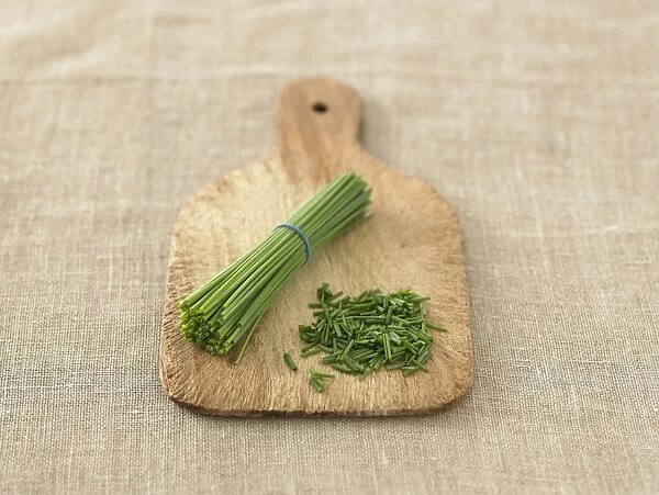 Chopped and whole chive stems on chopping board