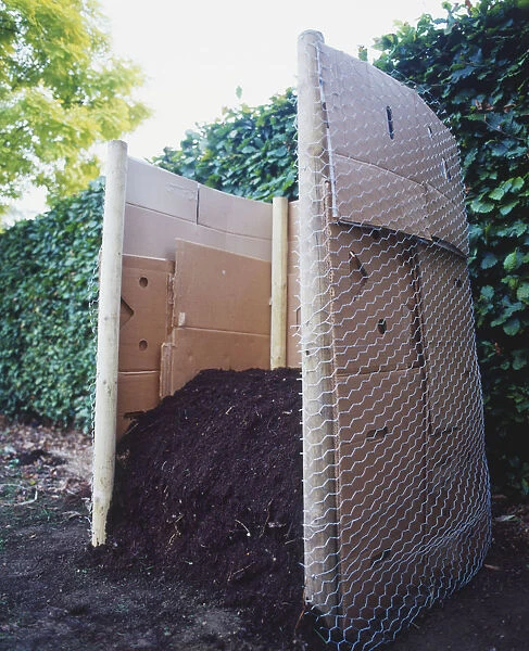 A compost heap lined with pieces of cardboard