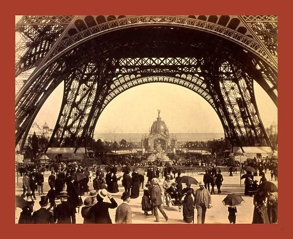 Crowd Of People Walking Under The Base Of Eiffel Tower