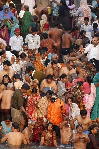 Devotees and holy men take a dip in the river Ganges during Navsamvatsar