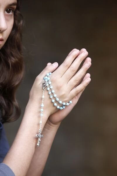 Girl praying with prayer beads