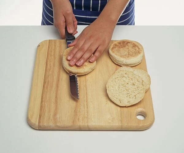 Girls hands cutting muffins through the middle, using a bread knife, close-up