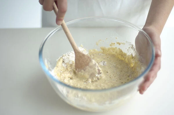 Hand mixing pancake batter in bowl, close-up