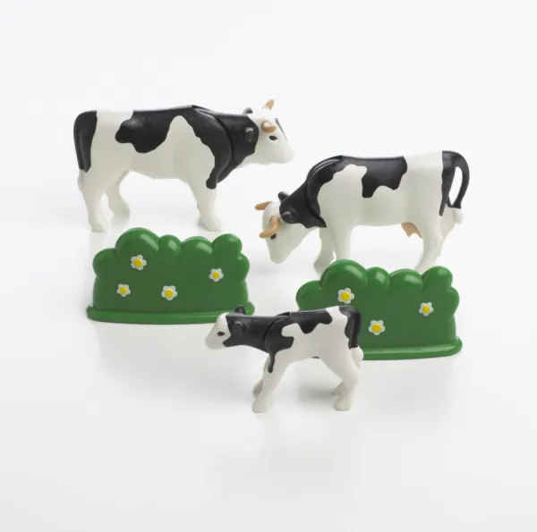 Two plastic toy cows, a calf and hedges