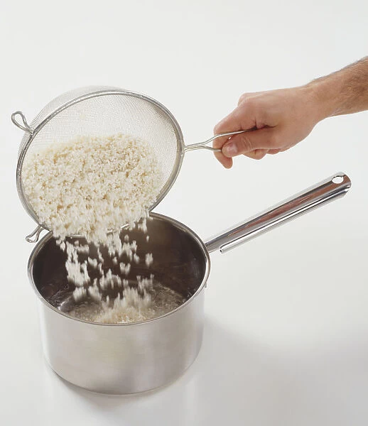 Pouring washed rice from sieve into saucepan filled one third with water, blurred motion