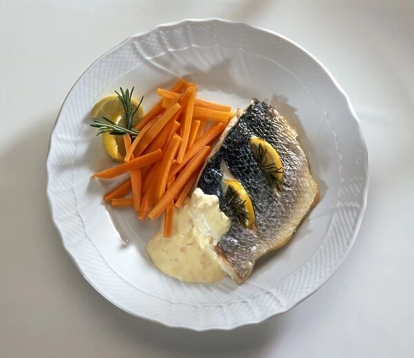 Sea bass fillet garnished with lemon and thyme and served with carrots and beurre blanc butter sauce, on a plate