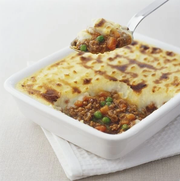 Shepherds pie being spooned out of square dish, close up