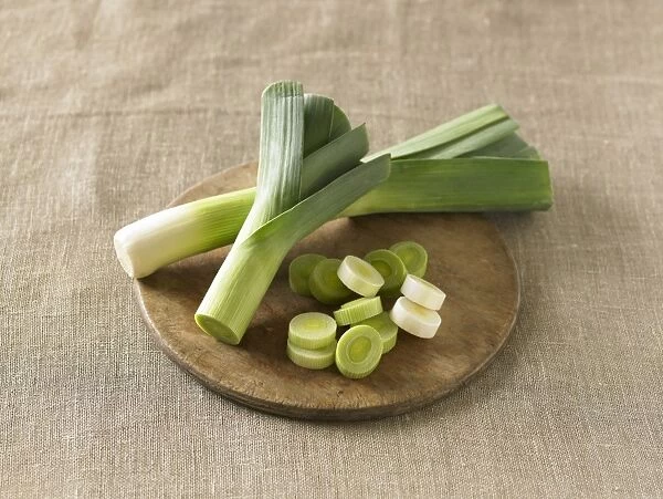 Whole and sliced leeks on chopping board
