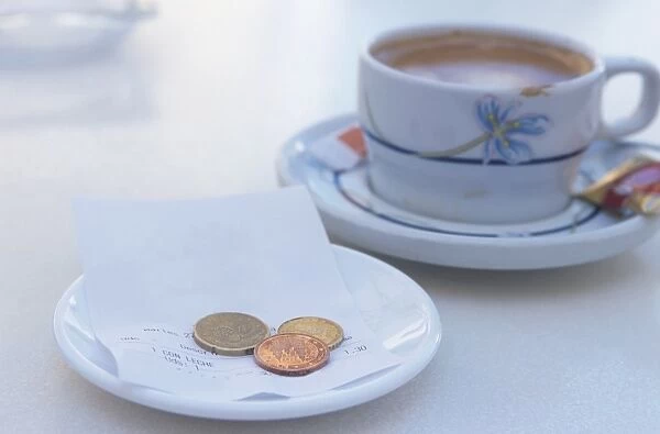 Spain, Costa Blanca, receipt and coins on plate near cup of coffee