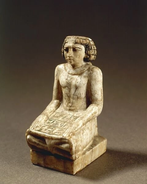 Statuette representing a scribe sitting cross-legged on the floor with hands on thighs and a papyrus scroll opened on the skirt