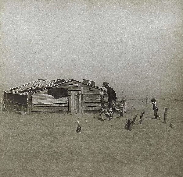 Storm in the Dust Bowl, America, 1930s. Man and boys walking towards wooden hut gradually