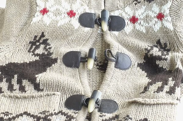 Toggle fastenings on brown knitted woollen cardigan, close-up