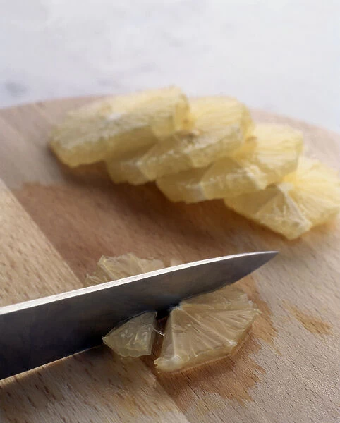 Using kitchen knife to cut skinless lemon slice into quarters