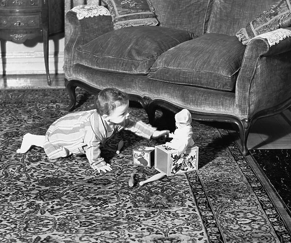 Baby girl (6-9 months) playing on floor, (B&W)