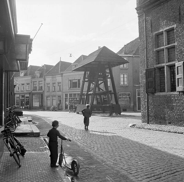 A child of the Haanapel family holds his scooter and watches the street in the town of Doesburg