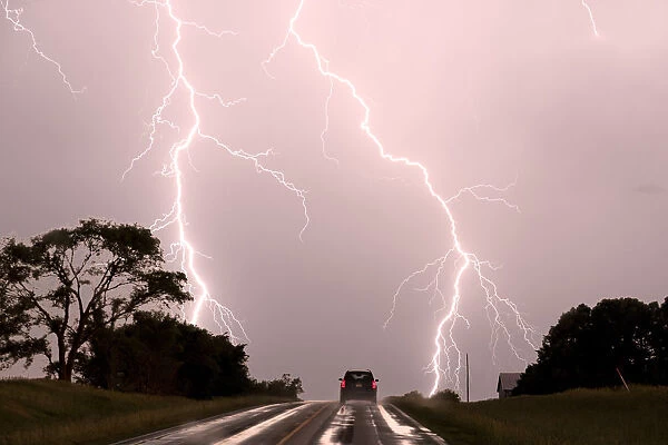 Driving into the storm, Double lightning bolts over highway. Nebraska. USA