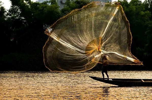 Fisherman catch fish in the river in Hue, Vietnam