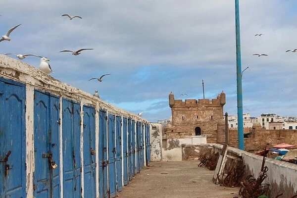 Fishermens huts and Genoese-built citadel in Essaouira harbour, on Atlantic coast of Morocco