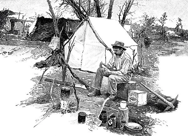 Man sitting outside tent reading a letter